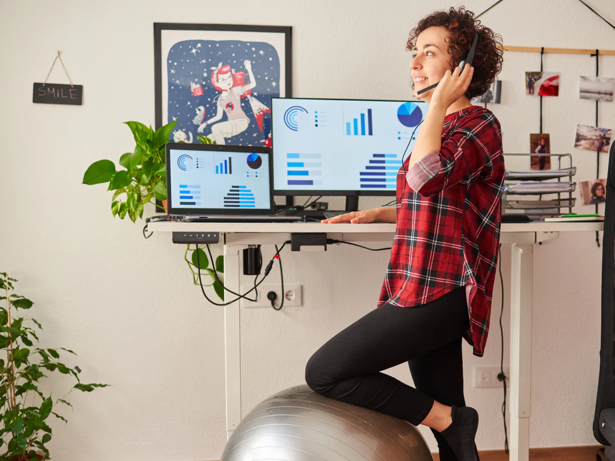 Person standing at a desk while working, illustrating prolonged standing during the workday.